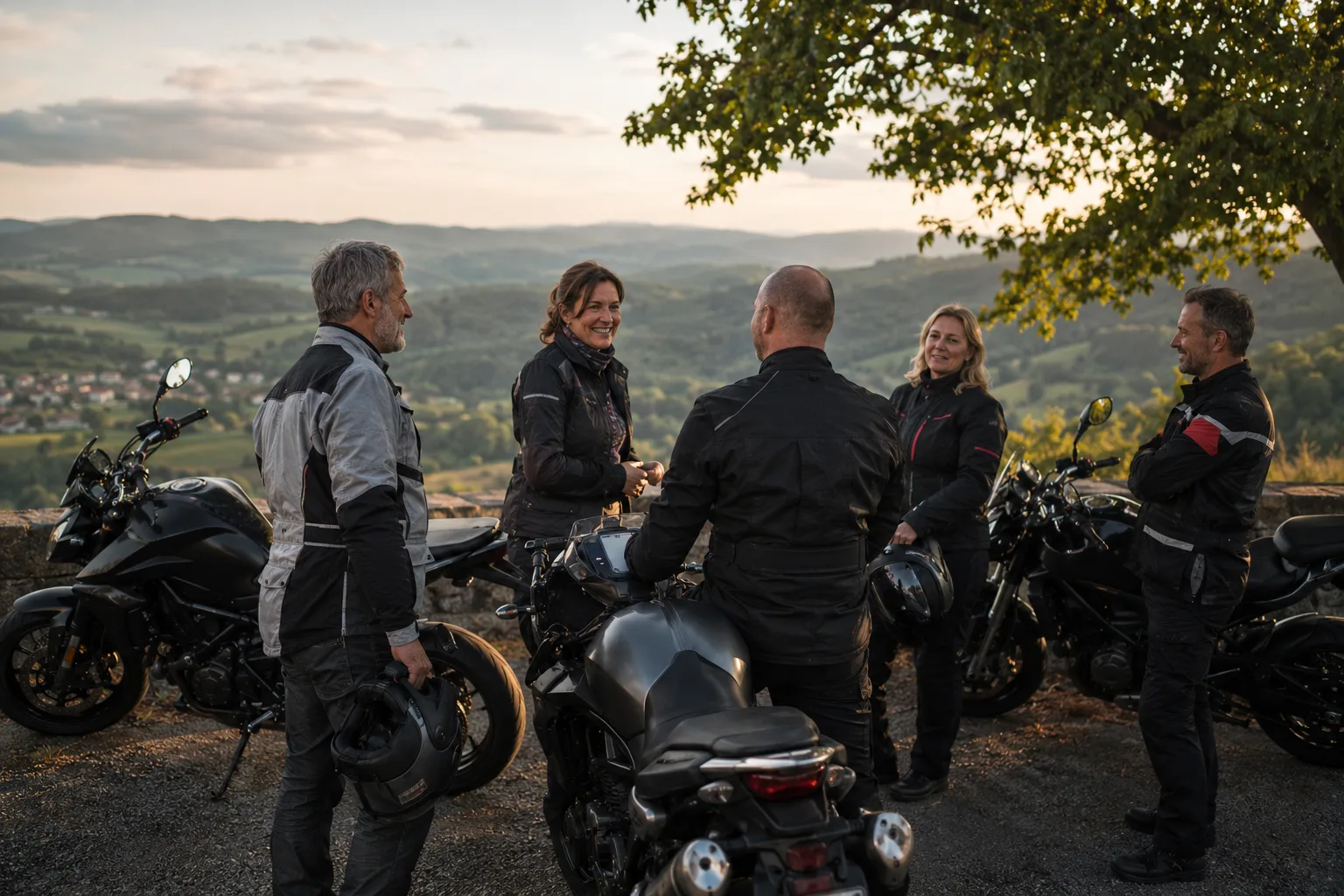 Motorradgruppe im Gespräch neben ihren Motorrädern an einem Aussichtspunkt
